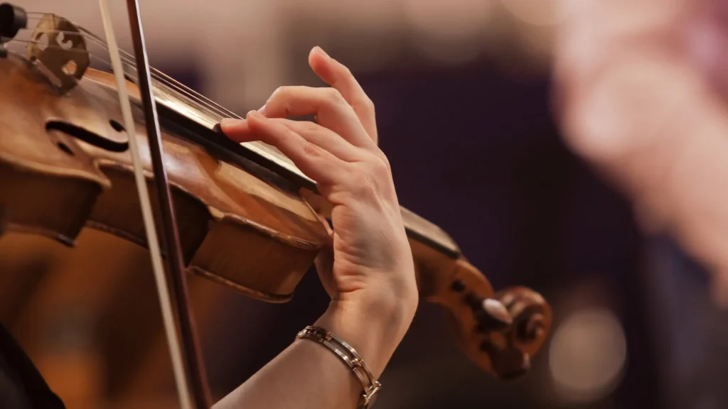Close-up of Aria Volenne's hand on the violin fingerboard